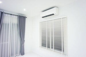 Air conditioner (ac) wall mount or indoor unit. Include Adjusting vertical or venetian blinds, eyelet curtains both blackout and translucent. Air conditioner is part of air conditioning HVAC split system consist of electric fan, filter and evaporator coil for climate, temperature and humidity control. To cool or cold in room of home or house building at night.